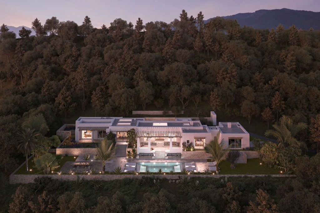 Image of a modern hillside villa in Ibiza surrounded by dense trees, featuring a central pool, landscaped gardens, and warm evening lighting.