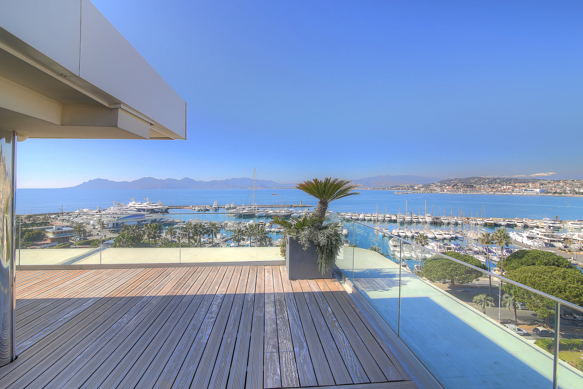 Image of a spacious terrace of a Cannes apartment for sale with outdoor seating and a stunning panoramic view of the sea.