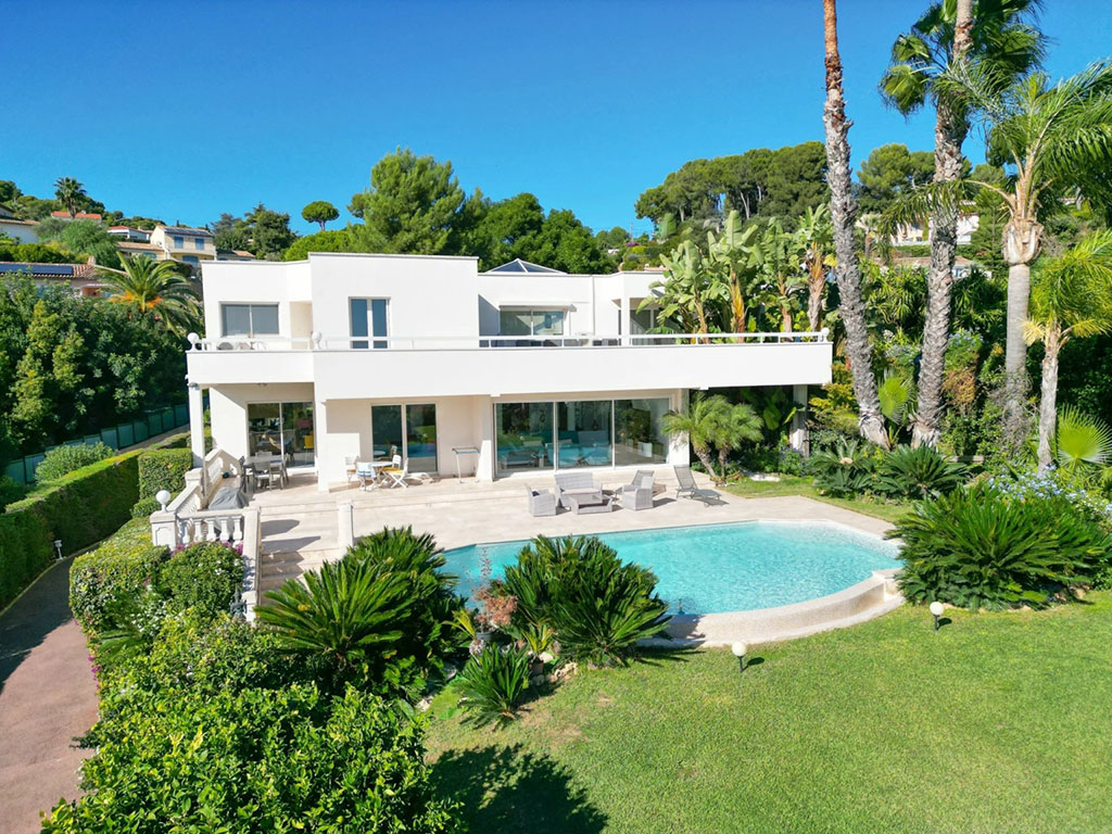 Cap d'Antibes vs St-Jean-Cap-Ferrat: Which Prestigious Address is Right for You? 3 Image of a modern, white luxury villa in Antibes, France