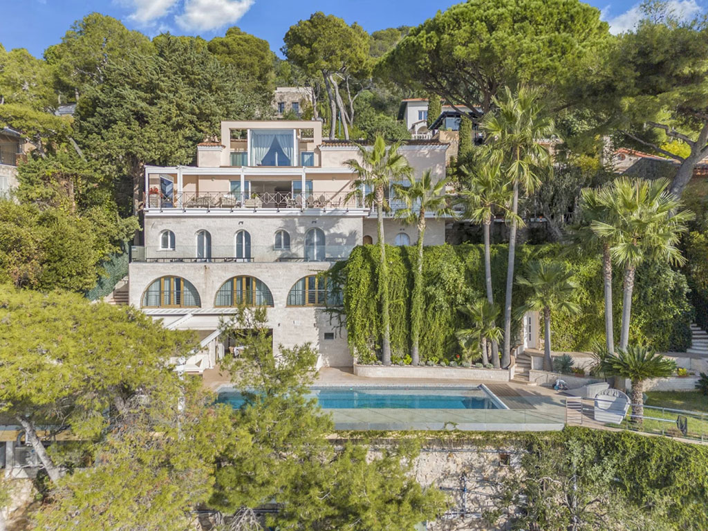 Cap d'Antibes vs St-Jean-Cap-Ferrat: Which Prestigious Address is Right for You? 4 Image of a stunning luxury villa in St Jean Cap Ferrat surrounding by palm trees